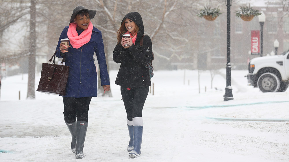 Two PennWest California students walk outside on a winter day.